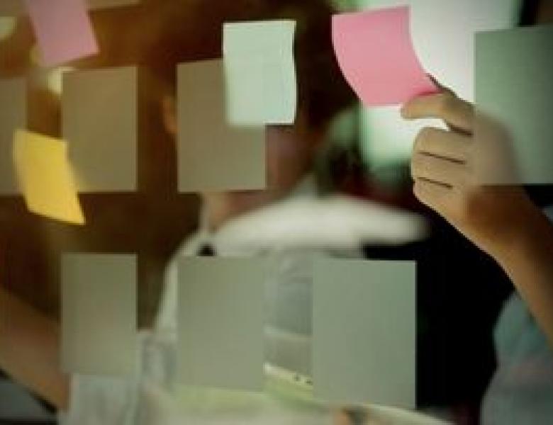 Man poñendo post-its nun vidro.